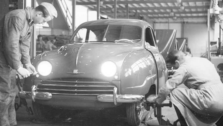 Saab 92 på produktionslinan. Två montörer arbetar.